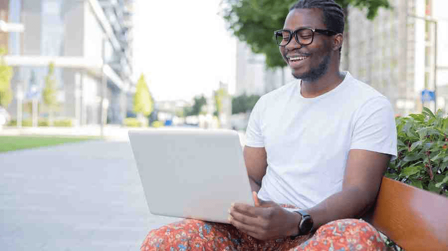 A pre-med student on a gap year studying for the MCAT outside in front of a laptop.